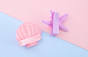 Detailed back view of pink scallop and purple starfish sequin clips for girls
