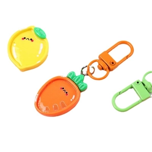 Cute fruit resin keychains with carrot and lemon shapes on white background