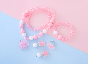 Detailed set of pink beaded children's jewelry featuring snowflake charms and pearls