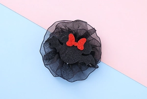 Detail of Minnie bat ear hair clip with black organza flower and red sequined bow accessory