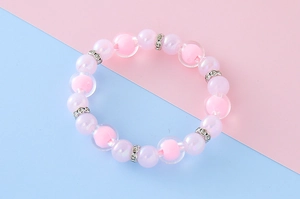 Détail de bracelet perles roses et mauves avec des intercalaires en strass brillants