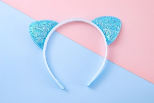Detail von glitzerndem blauem Katzenohr-Stirnband mit rutschfesten Zähnen auf weißem Band
