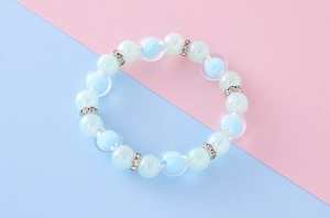 Gros plan de perles bleu pastel givrées et de perles blanches nacrées sur le bracelet