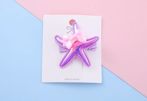 Detail of purple holographic starfish hair clip with pink mesh bow for kids
