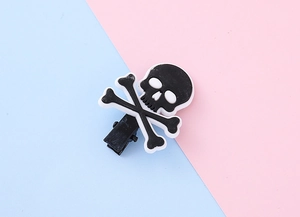 Détail d'une pince à cheveux d'Halloween avec un crâne 3D sur un support métallique noir