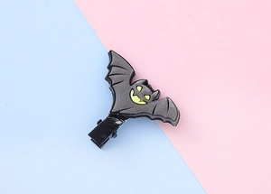 Détail d'une pince à cheveux chauve-souris en PVC gris avec yeux jaunes pour Halloween