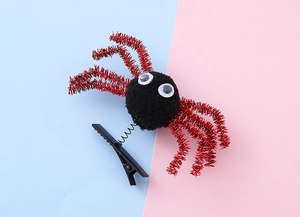 Detail of Halloween spider hair clip with red spring legs and googly eyes on metal grip
