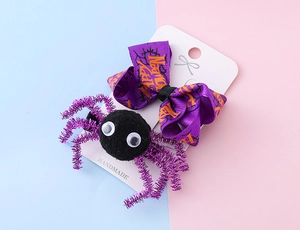 Détail de pinces à cheveux Halloween avec nœud violet et épingles araignée noires poilues