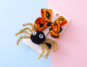 Détail de la pince à cheveux Halloween avec nœud orange et araignée sur support
