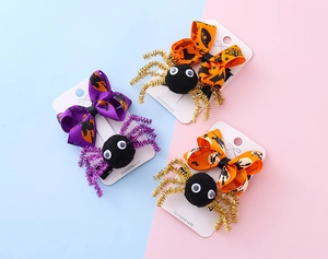 Détail de pinces à cheveux araignée Halloween avec ruban violet et motifs festifs