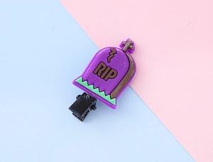 Détail d'une pince à cheveux tombeau RIP d'Halloween violette avec attache en métal robuste