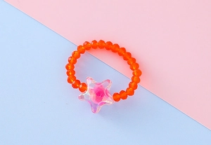 Dettaglio anello elastico con perline arancioni e ciondolo a stella per bimbi