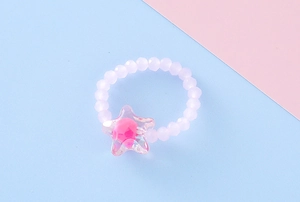 Dettaglio dell'anello con perline lavanda e ciondolo a stella con perla rosa interna