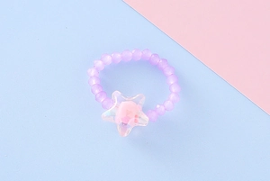 Dettaglio anello elastico con perline viola e ciondolo a stella con rosa rosa interna