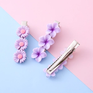 Dreiteiliges Set lila Blumen-Haarspangen aus Resina inklusive Gänseblümchen- und Blütenformen
