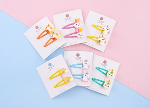 Dettaglio del set di fermagli per capelli glitterati con unicorno e arcobaleno