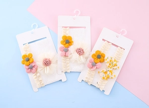 Detailansicht von elastischen Baby-Stirnbändern mit Strickblumen und floralen Schleifen
