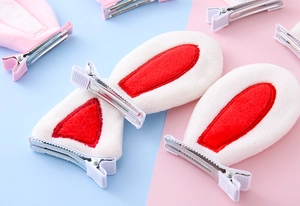 Close-up of plush rabbit ear hair clips with metal alligator clips and soft fur texture