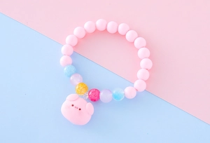 Détail des perles roses mates et du pendentif cochon mignon sur le bracelet enfant