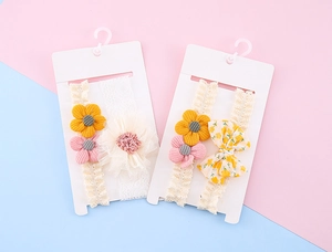 Detail von Baby-Stirnbändern mit Spitzenblumen und floralen Schleifen auf Displaykarten
