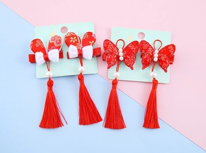 Close-up of Chinese New Year hair clips with red tassels, satin bows and rabbit charms