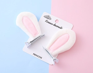 Detail of plush white and pink rabbit ear hair clips with metal alligator clips