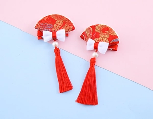 Close-up of traditional Chinese red bow hair clips with silk fans and long tassels