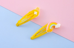 Dettaglio di fermagli per capelli unicorno gialli con ciondoli in resina e glitter