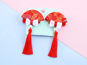 Detail of red Chinese New Year hair clips with embroidered fans and long pearl tassels