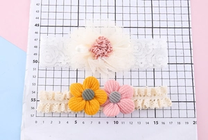 Detail von Baby-Stirnbändern aus Spitze mit 3D-Blumenakzenten in Rosa und Creme