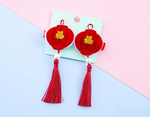 Detail of red lantern hair clips with Fu character, white pearls and long silk tassels