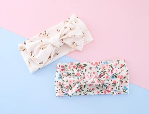 Detail showing ribbed knit texture and floral prints on baby bow headband sets