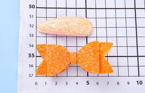 Comparaison de taille entre pince à paillettes rose et nœud orange pour enfants