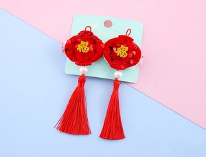 Macro shot of festive red sequin lantern hair clip with Fu character and silk tassel