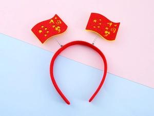 Dettaglio del cerchietto in feltro rosso con decorazioni festive a stella e bandiera