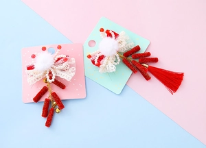 Détail de barrettes nœuds rouges festifs avec dentelle, perles et pompons du Nouvel An