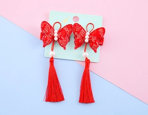 Detail of red Chinese New Year hair clips with gold embroidery, pearls, and long silk tassels