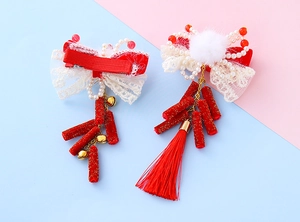 Vue détaillée des barrettes de Nouvel An chinois avec pompons rouges, perles et porte-bonheur