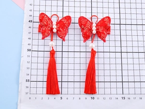 Detail of red brocade butterfly hair clip with gold embroidery and silk tassels