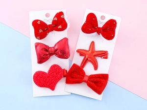 Detailed set of red plush and glitter bow hair clips for girls on display cards