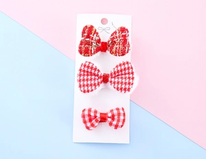 Detailed set of red festive hair clips for kids featuring plaid and tweed plush textures