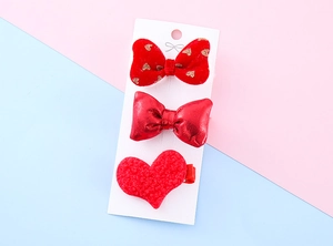 Detailed set of red festive hair clips with plush, velvet, and sequin heart textures