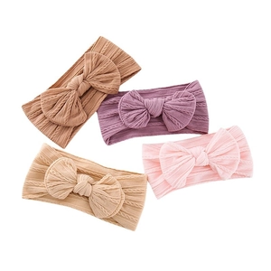 Set of four knitted baby headbands with large bows in brown, purple, beige and pink