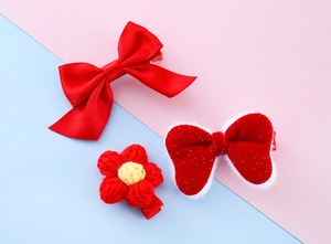 Detailed set of red bow hair clips and a crocheted flower for children's hair styling