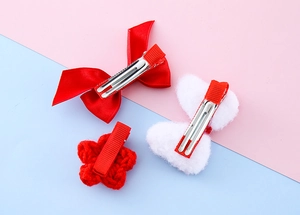 Detailed view of red silk bow, white plush clip and knitted star hair accessories set