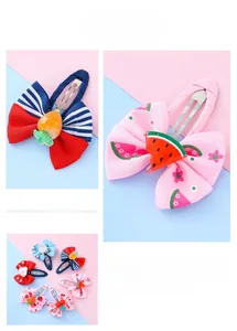 Detail of fabric-wrapped safety hair clips with cute resin fruit and heart decorations