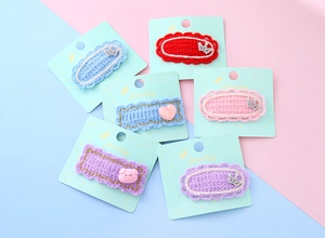 Détail de 6 barrettes tricotées avec couronnes scintillantes et motifs de dessins animés