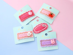 Détail de 5 barrettes en tricot avec lapins et couronne sur cartes de présentation