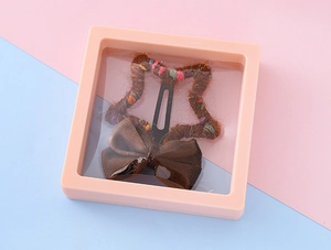 Barrette étoile en peluche avec nœud dans sa boîte d'exposition rose