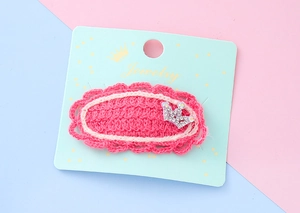 Détail de la barrette en tricot rose avec petite couronne en strass sur carte